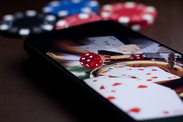 A professional dealer in a tuxedo greeting players at the roulette table, symbolizing the authentic live casino feel at ILOTBEF.