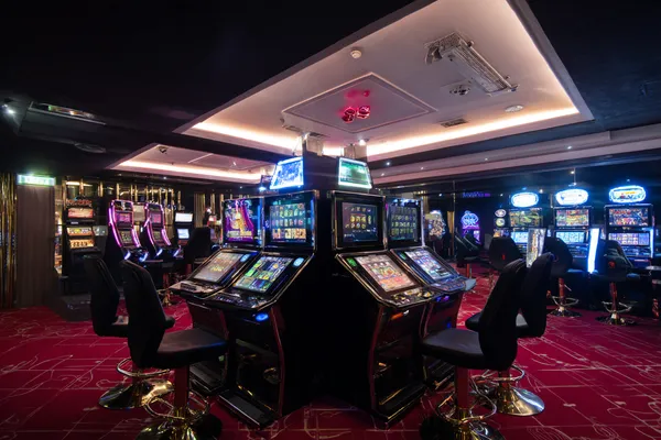 A woman in a luxurious green gown next to an ornate roulette wheel, capturing the upscale casino mood of ILOTBEF.